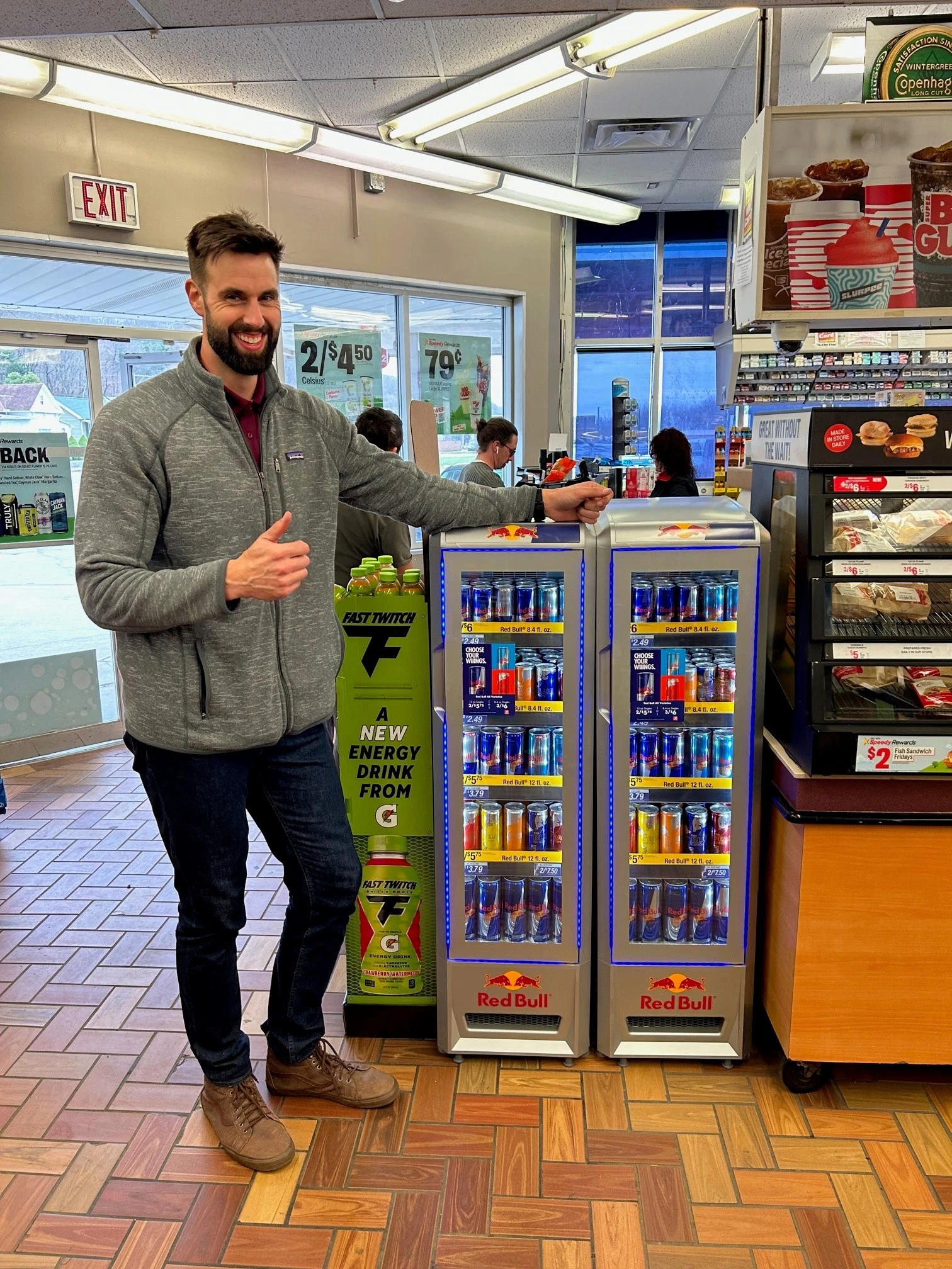 Dixie employee standing next to a Red Bull fridge